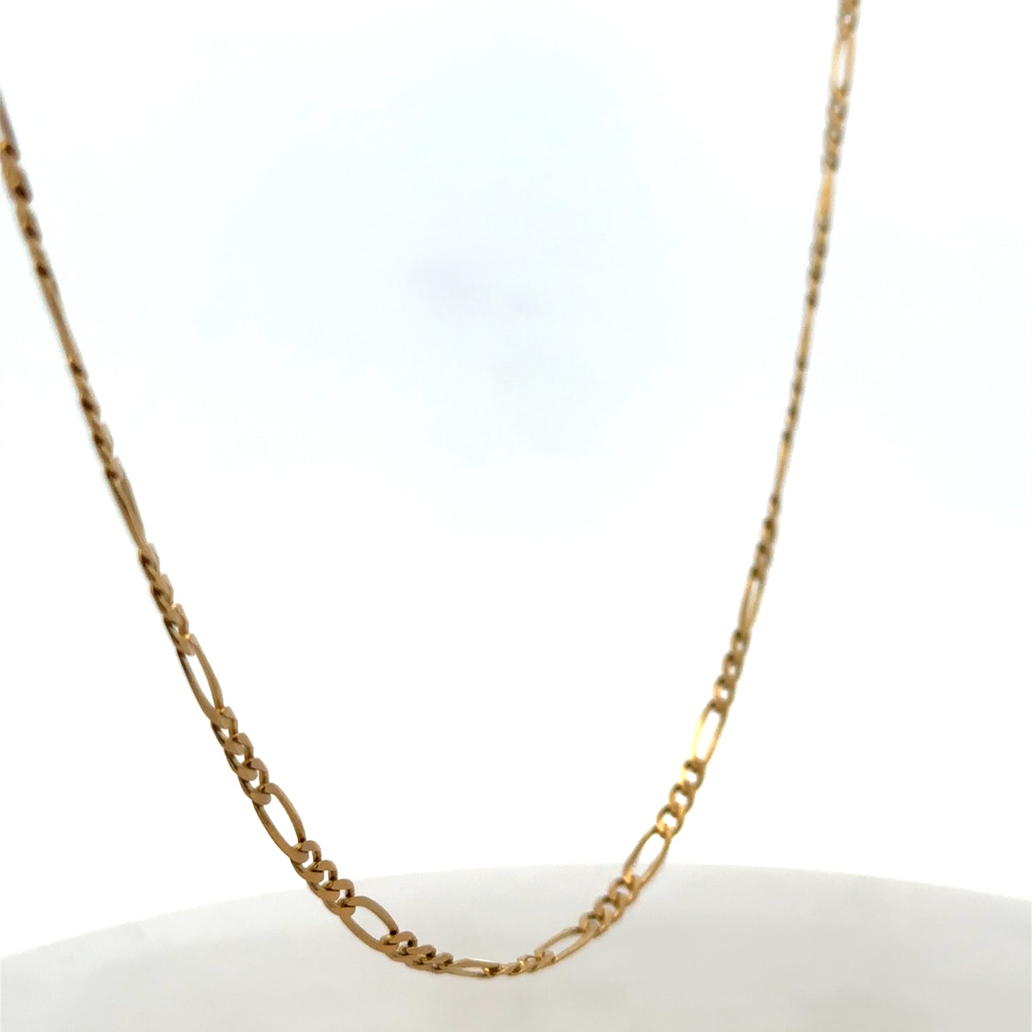 9ct yellow gold figaro chain from Reeves and Sons, showcasing its linked chain design and polished finish.