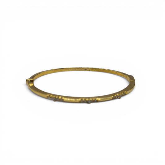 18ct yellow gold diamond bangle by Reeves and Sons with sparkling diamonds and smooth gold finish, displayed on a neutral background.