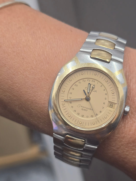 Vintage Omega Seamaster Polaris Chronograph watch with steel and gold case, displaying a black dial and chronograph subdials.