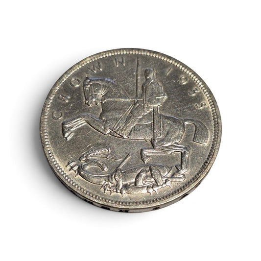 Silver coin featuring King George V and a rocking horse design, British Jubilee five shilling coin by Reeves and Sons.