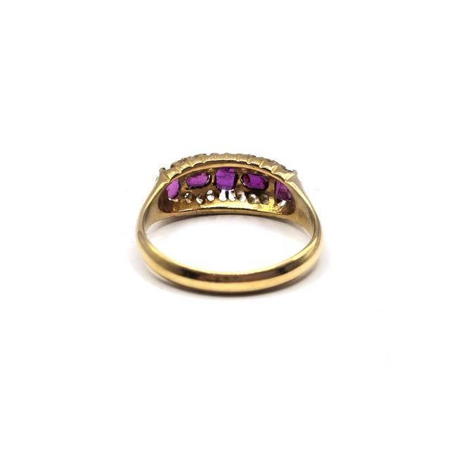 18ct ruby and diamond ring with a gold band, featuring a central ruby surrounded by sparkling diamonds