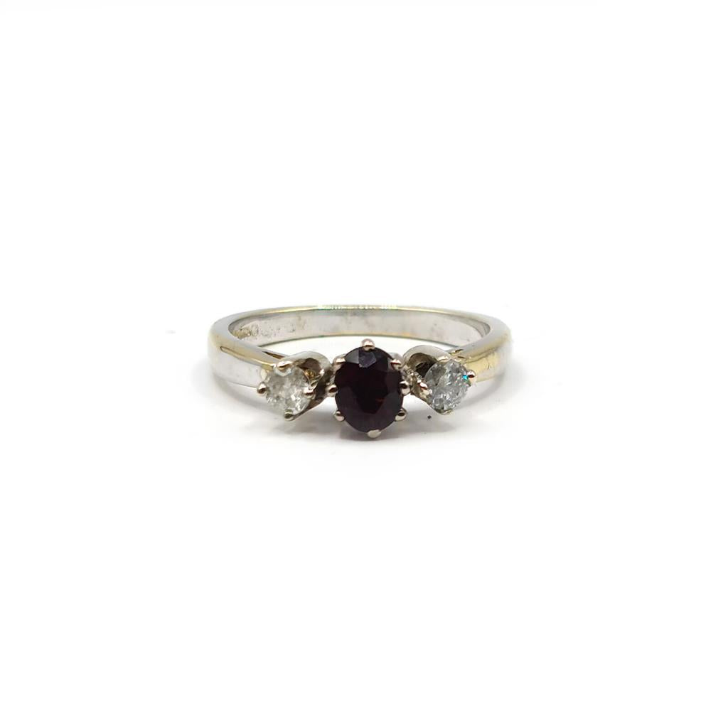 18ct white gold ring with 0.24 carat diamonds and 0.45 carat garnet gemstone, showcasing elegant jewelry design.