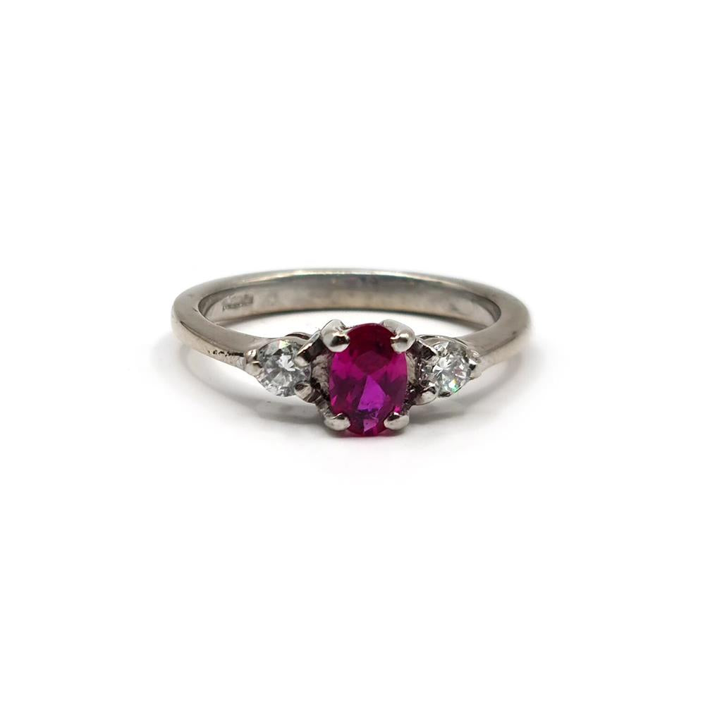 18ct white gold ring with a 0.55 carat ruby center stone and 0.20 carat diamonds, featuring a sleek, elegant design.
