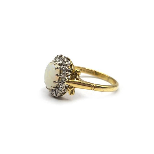 18ct yellow gold opal and diamond ring with a central opal and surrounding diamonds, elegant jewelry design.