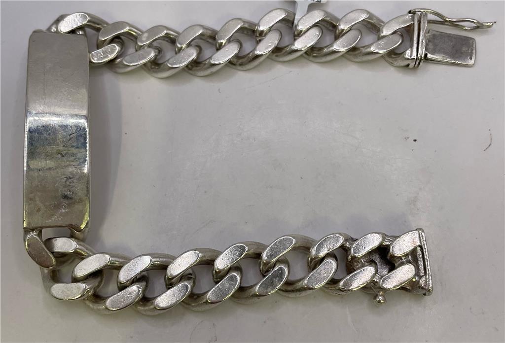 Sterling silver ID bracelet with engraved plate, unbranded, showcasing a sleek and polished design on a plain background.