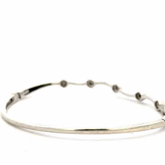 9ct white gold diamond bangle with sparkling diamonds, weighing 7.7g, elegant jewelry piece featuring a sleek design.