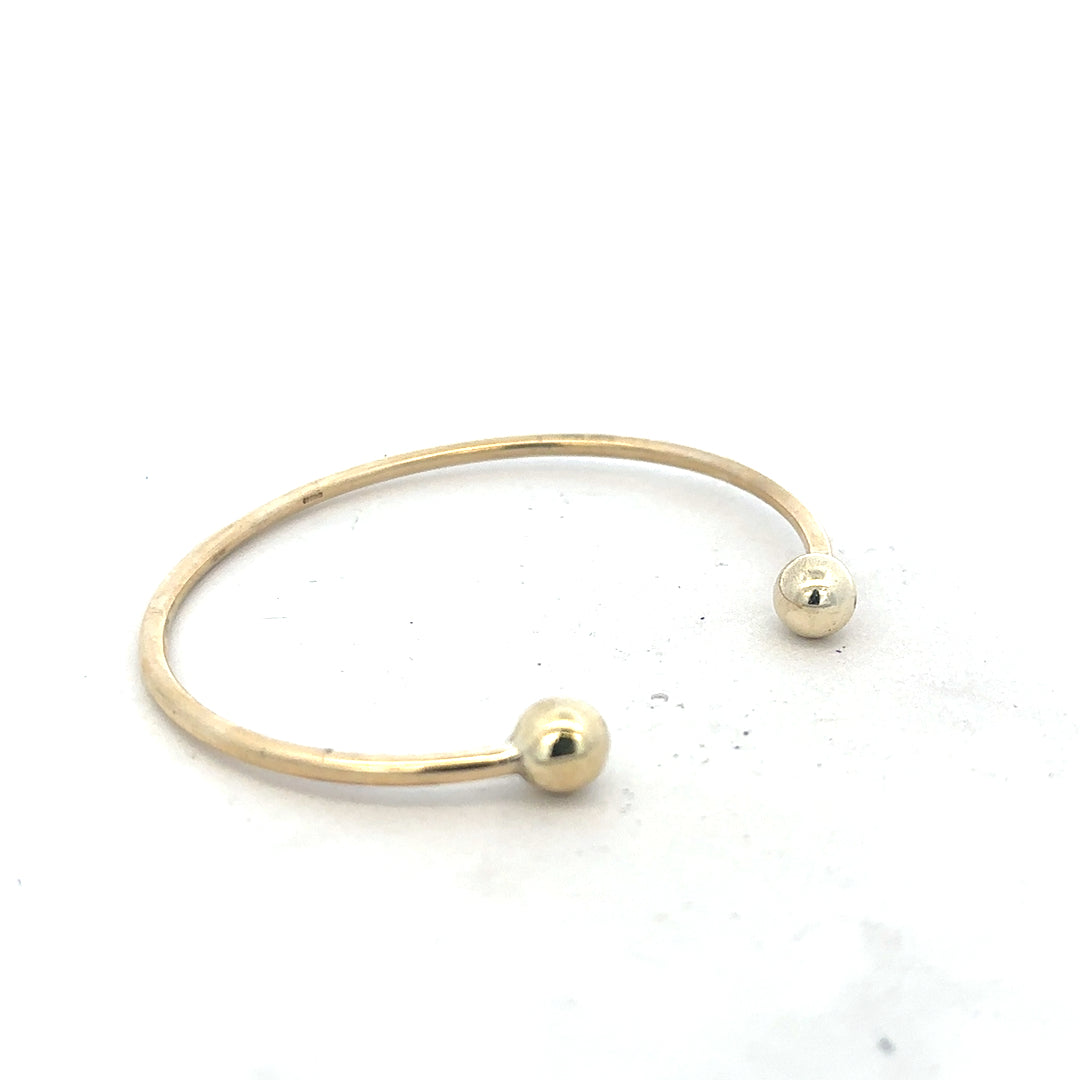 9ct yellow gold bangle weighing 12.7g, unbranded jewelry accessory with a smooth, polished finish, displayed on a neutral background.