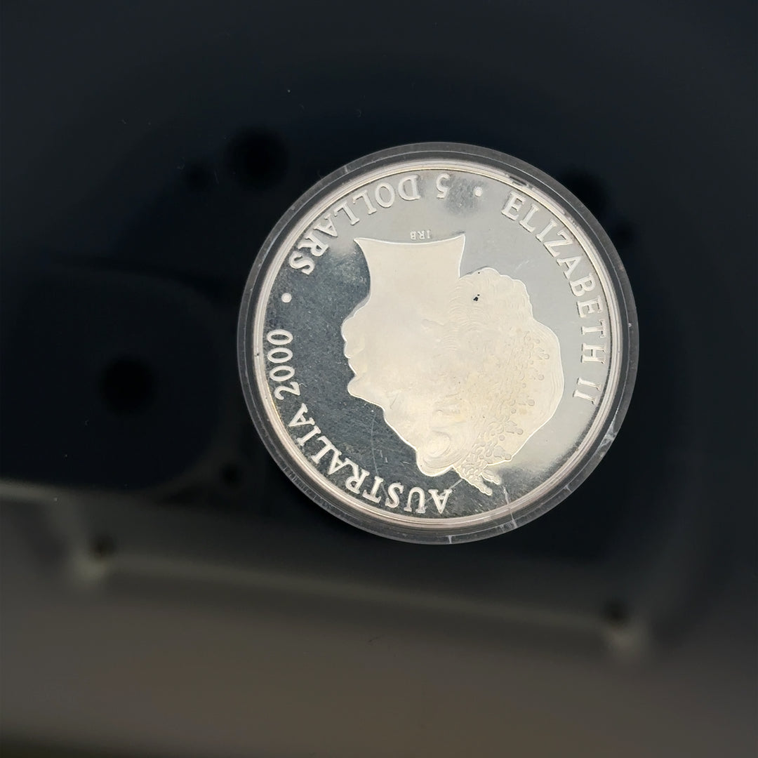 Silver 2000 Olympic coin, 31.4g, unbranded, featuring Olympic design and commemorative details, close-up view of the coin.