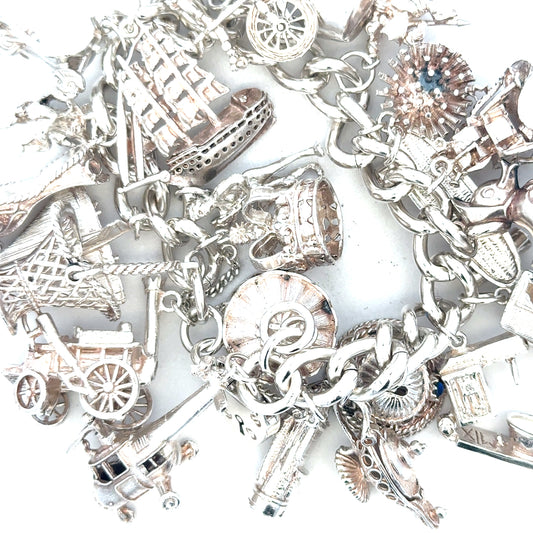 Silver charm bracelet weighing 154.4g with intricate charms and links, unbranded jewelry accessory for stylish wear.