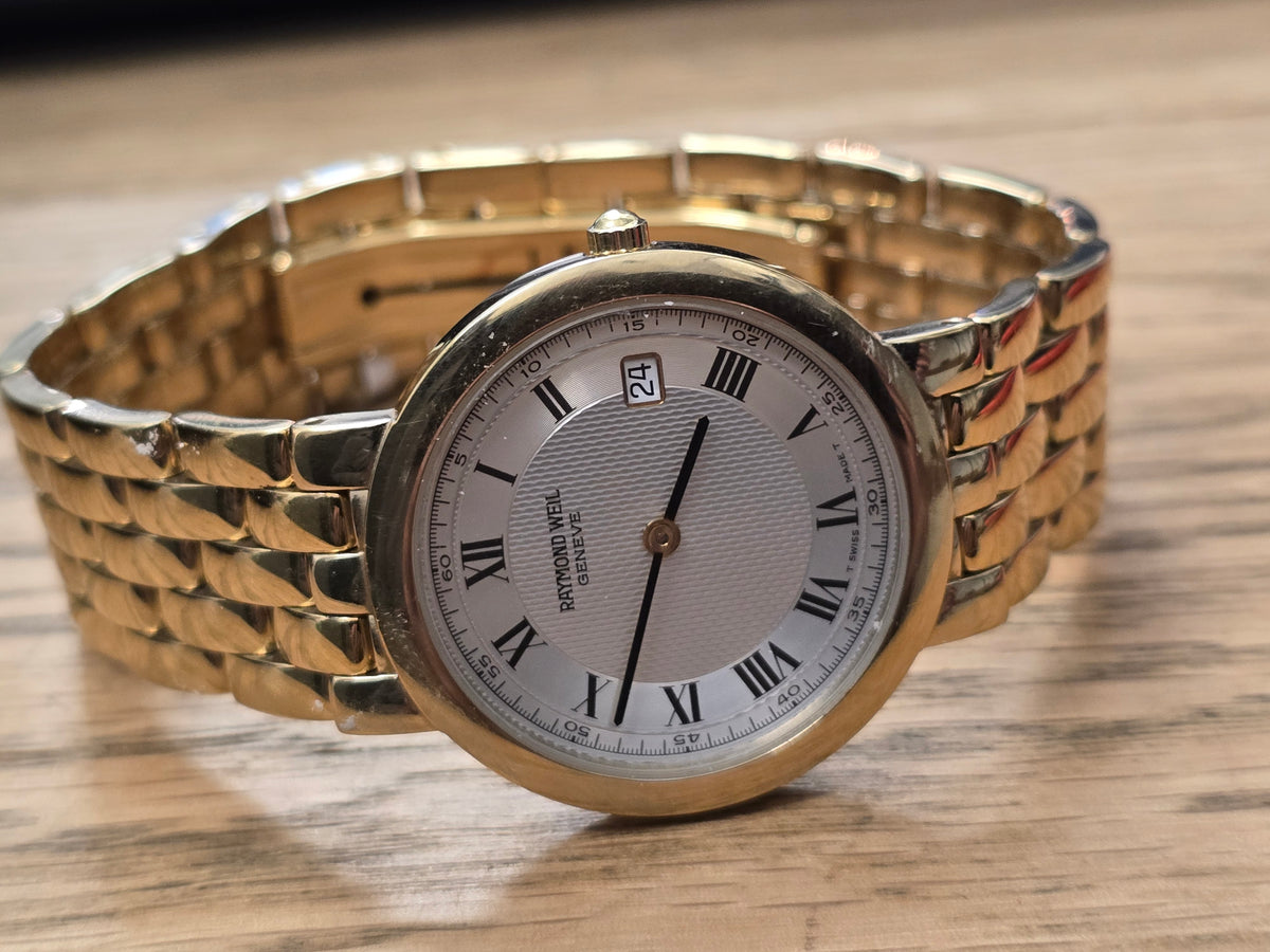 Raymond Weil Geneve gold-plated quartz watch with white Roman numeral dial and date display by Reeves and Sons