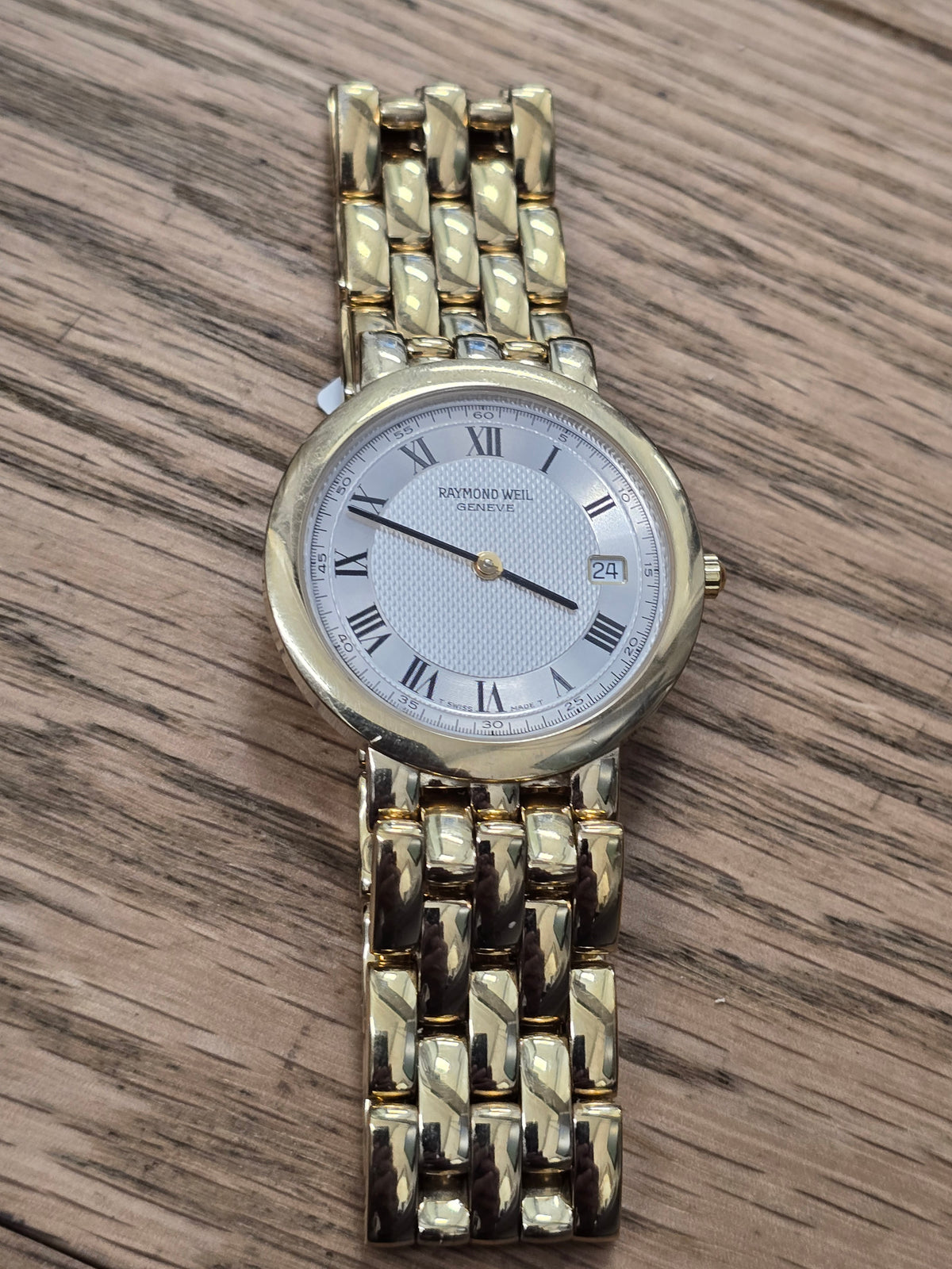 Raymond Weil Geneve gold plated quartz watch with white Roman numeral dial and date display by Reeves and Sons