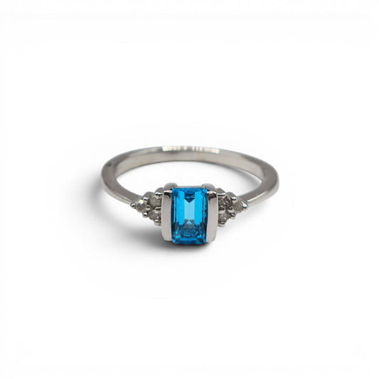 9ct white gold ring with topaz and diamond accents, crafted by Reeves and Sons, featuring a sparkling gemstone design.