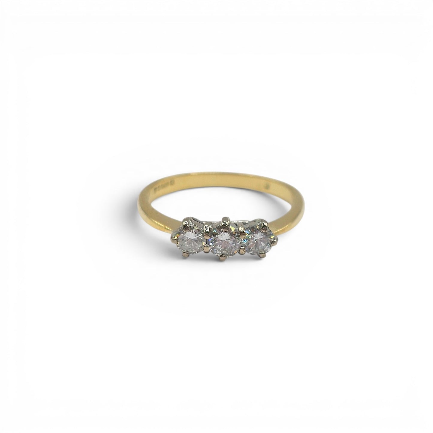 18ct yellow gold three-stone diamond ring by Reeves and Sons, featuring three sparkling diamonds and a polished gold band.