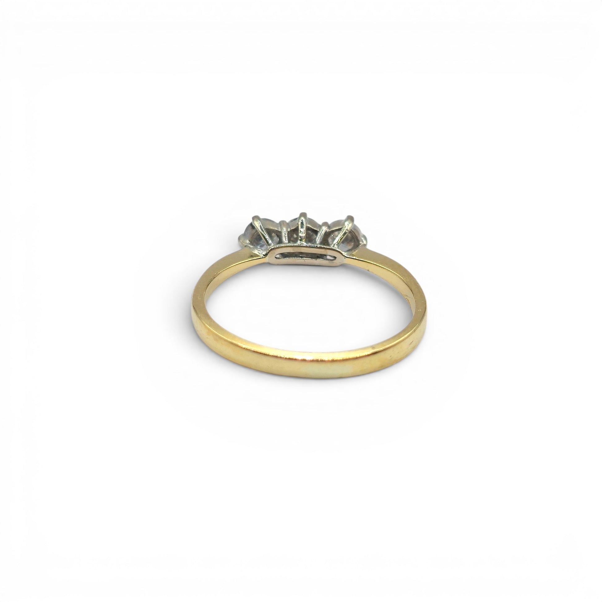 18ct yellow gold three-stone diamond ring by Reeves and Sons, featuring a central diamond with two side stones on a polished band.