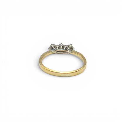 18ct yellow gold three-stone diamond ring by Reeves and Sons, featuring a central diamond with two side stones on a polished band.