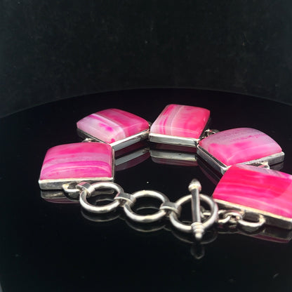 Silver gemstone bracelet with polished stones and adjustable clasp, featuring a sleek and elegant design.