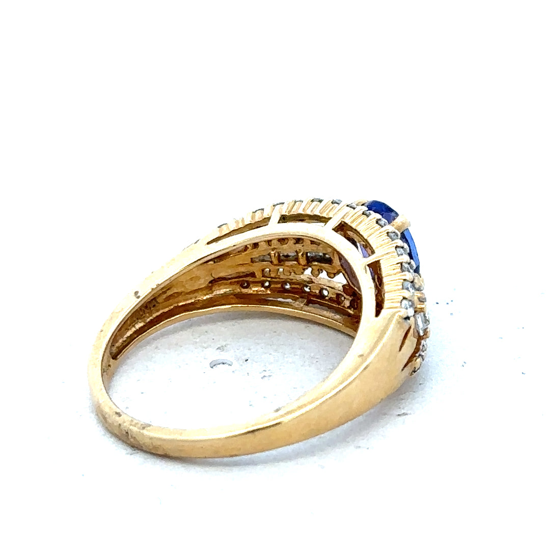 18ct yellow gold diamond and tanzanite ring size N1/2 with intricate design and sparkling gemstones on a white background.