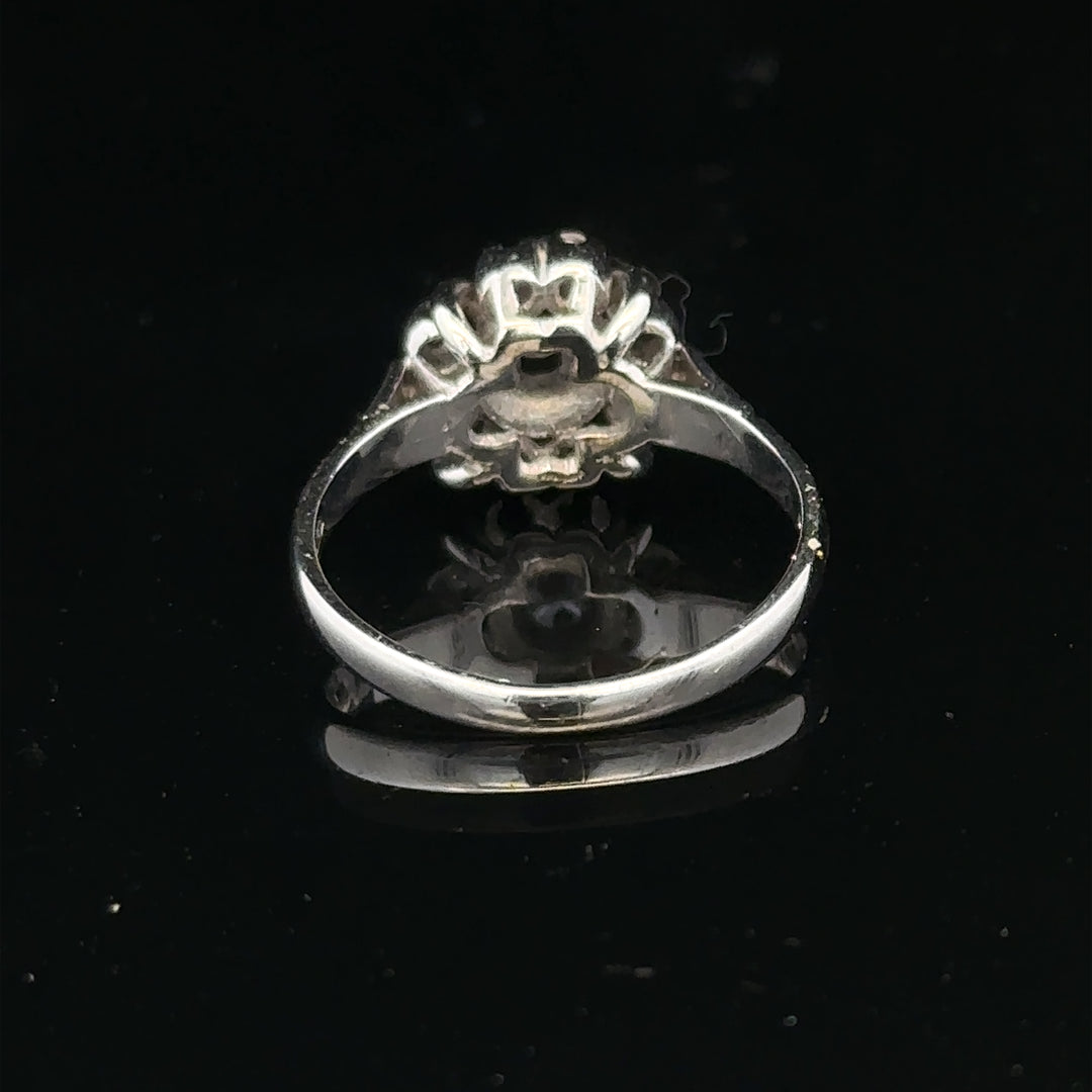 9ct white gold cluster diamond ring by Reeves and Sons featuring a sparkling diamond design and intricate metalwork.