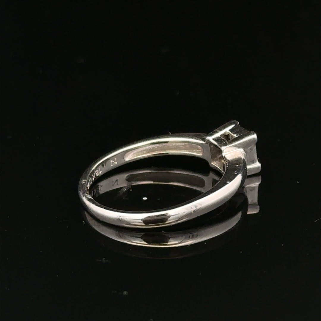 18ct white gold diamond ring with a central diamond, size J1/2, showcasing elegant jewelry craftsmanship.