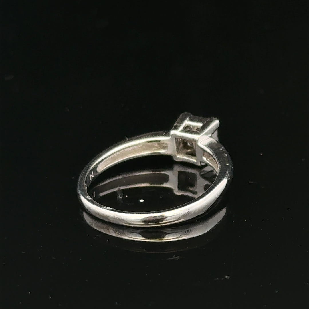 18ct white gold diamond ring with a central diamond, size J1/2, featuring elegant craftsmanship and sparkling gemstone details.
