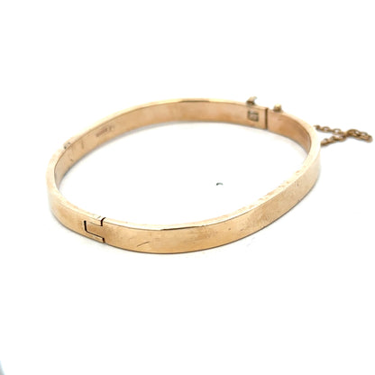 9ct yellow gold bangle weighing 24.1g with a smooth, polished finish, featuring a classic rounded design by Reeves and Sons.