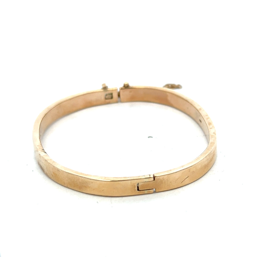 9ct yellow gold bangle weighing 24.1g with Reeves and Sons branding, featuring a smooth, polished finish and classic design.