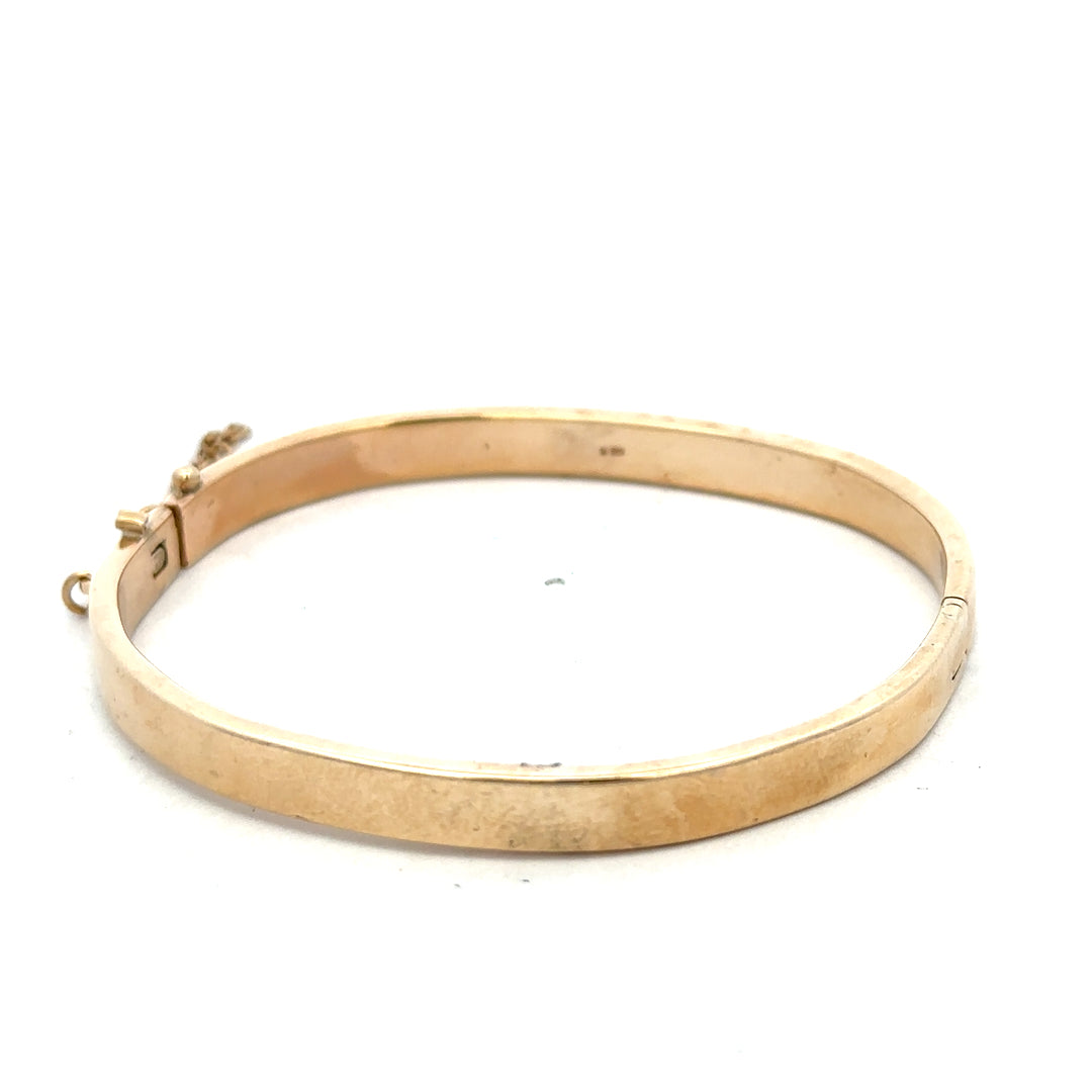 9ct yellow gold bangle weighing 24.1g from Reeves and Sons, smooth and polished jewelry accessory shown in the image.