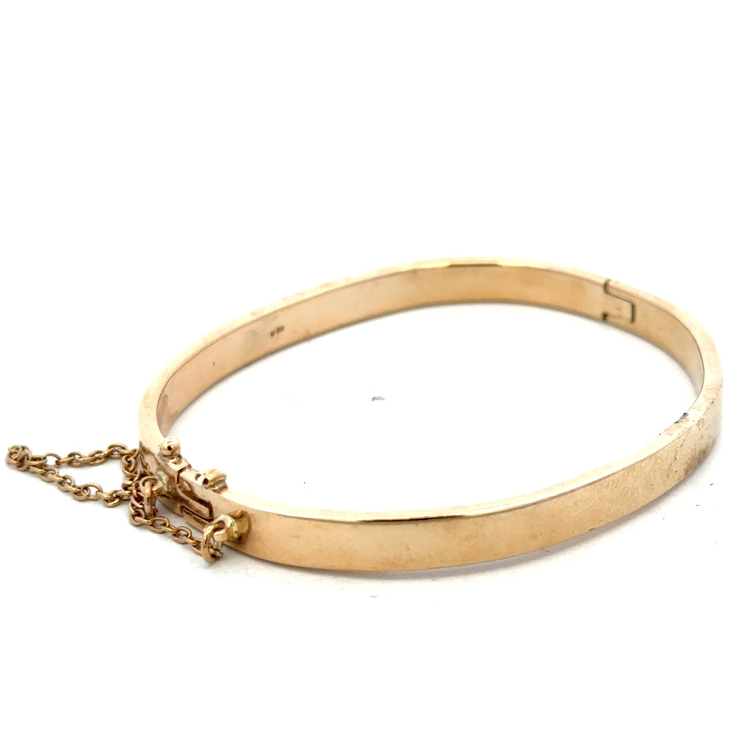 9ct yellow gold bangle weighing 24.1g with a smooth, polished finish, crafted by Reeves and Sons.