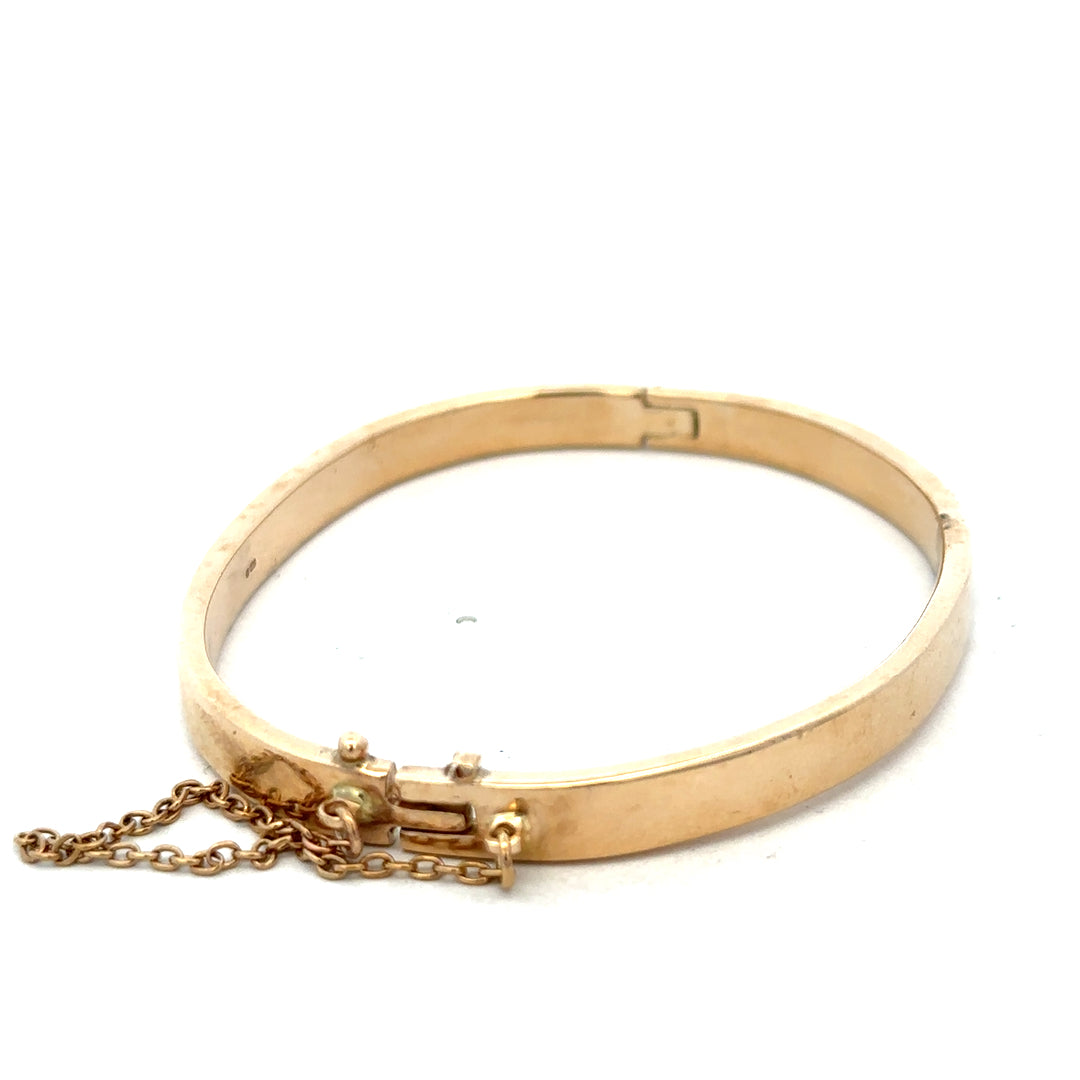 9ct yellow gold bangle weighing 24.1g, featuring a smooth, polished finish, from Reeves and Sons.