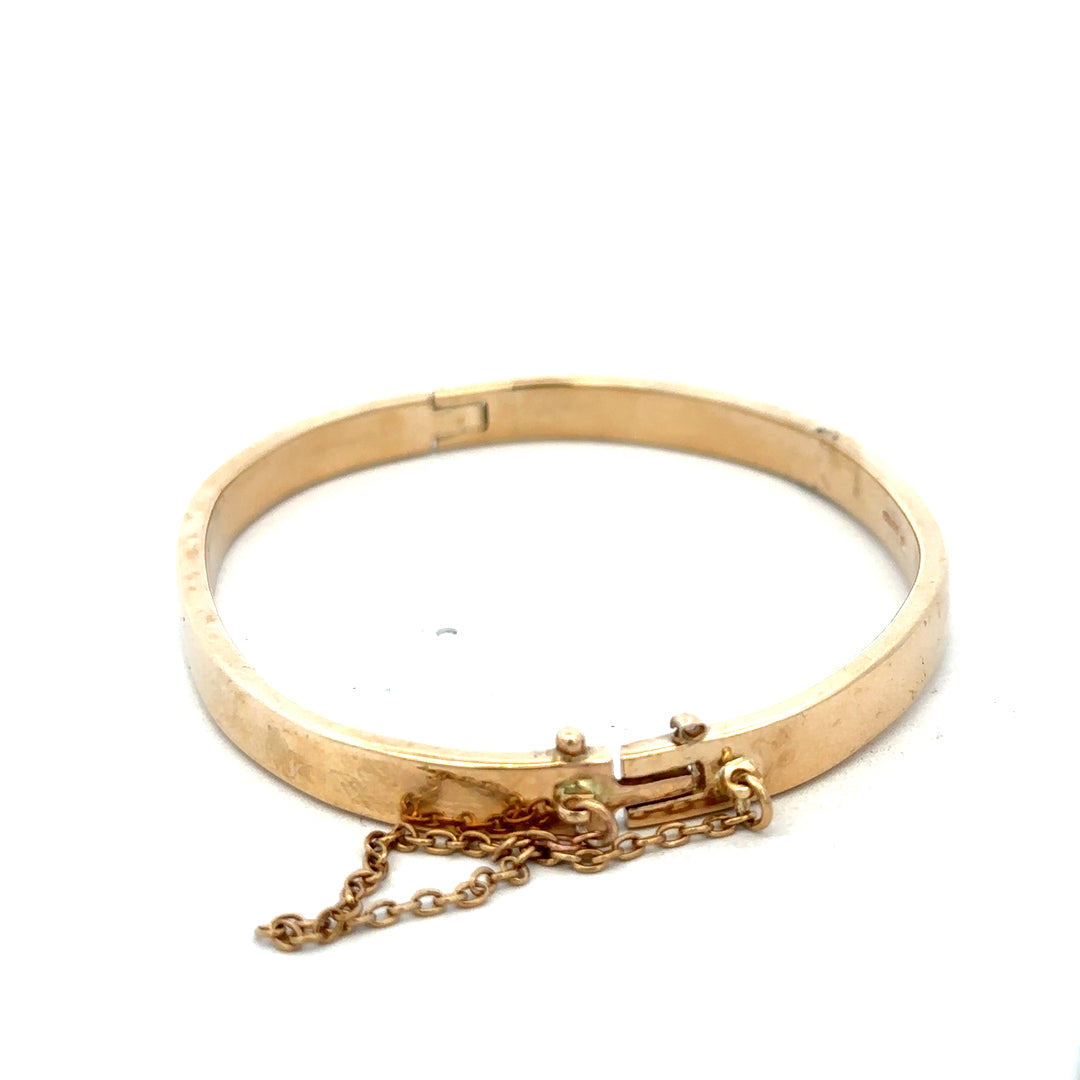 9ct yellow gold bangle weighing 24.1g with smooth polished finish, crafted by Reeves and Sons, displayed on a neutral background.