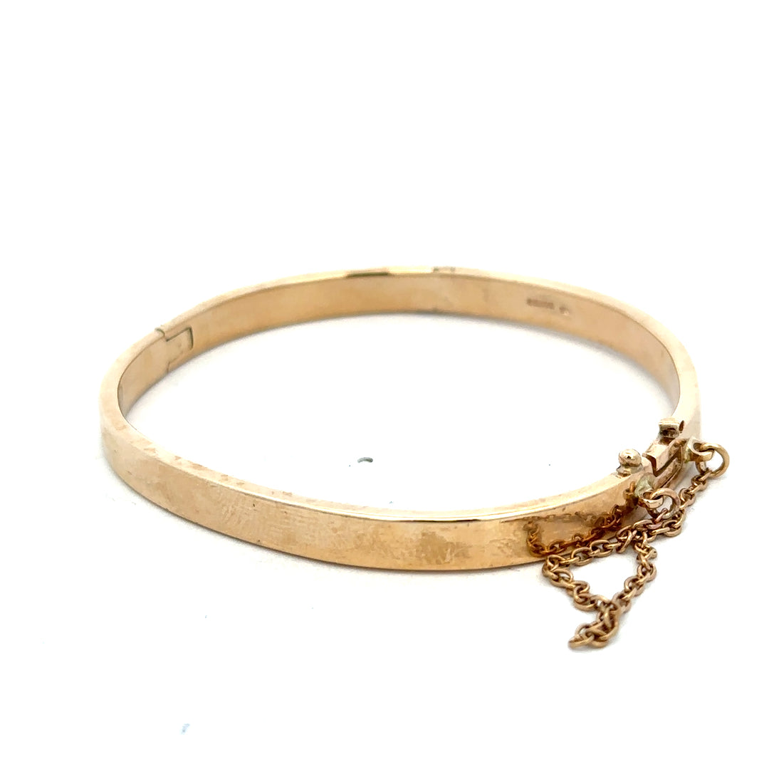 9ct yellow gold bangle weighing 24.1g with smooth, polished finish, crafted by Reeves and Sons.