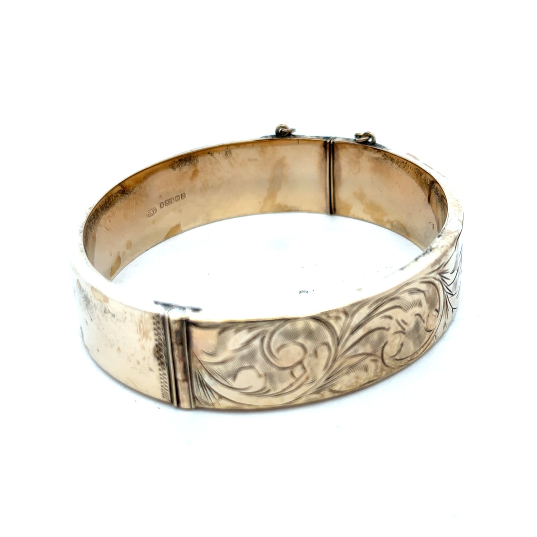 9ct yellow gold bangle with a smooth finish, weighing 22.7g, from Reeves and Sons, displayed on a white background.