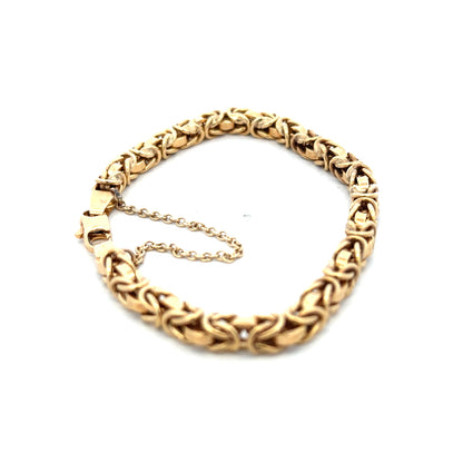 9ct yellow gold bracelet weighing 10.8g with intricate link design from Reeves and Sons, displayed on a neutral background.