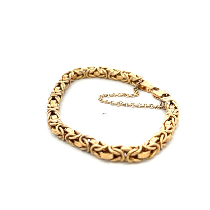 9ct yellow gold bracelet weighing 10.8g with a detailed chain design, crafted by Reeves and Sons.