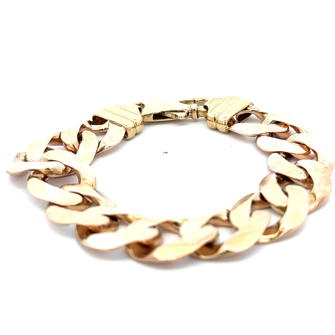9ct yellow gold curb bracelet weighing 63.6g, featuring a classic linked design, displayed on a neutral background.
