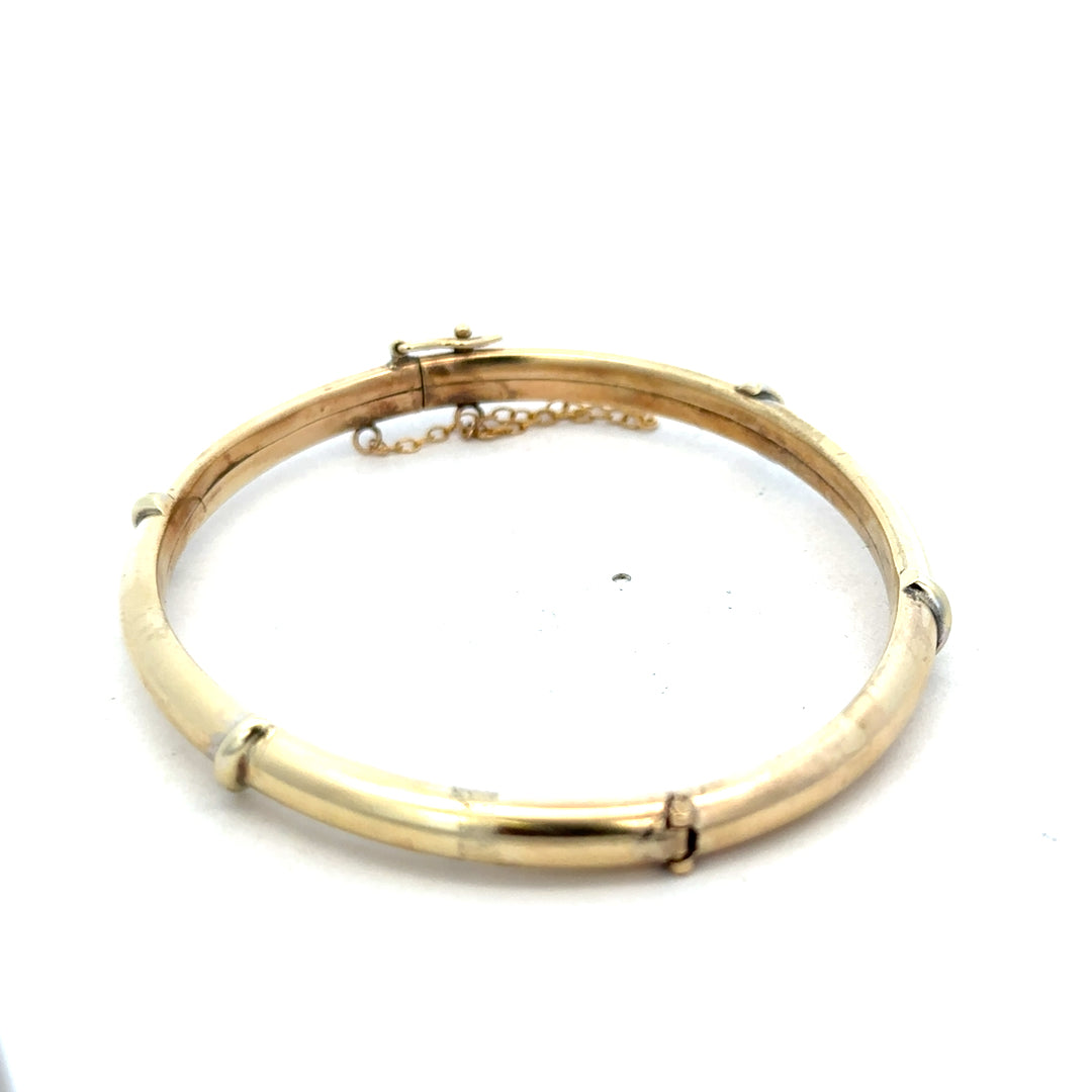 9ct yellow gold bangle weighing 11.1g, featuring a sleek, polished design from Reeves and Sons.