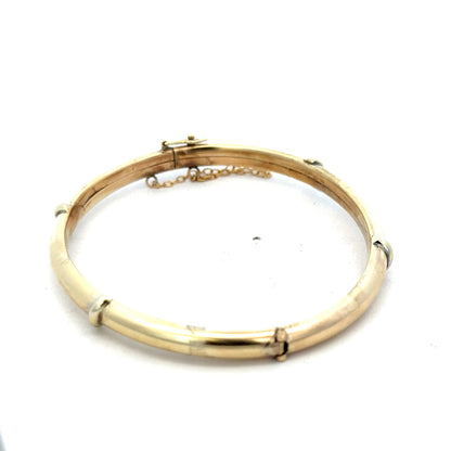 9ct yellow gold bangle weighing 11.1g, featuring a sleek, polished design from Reeves and Sons.
