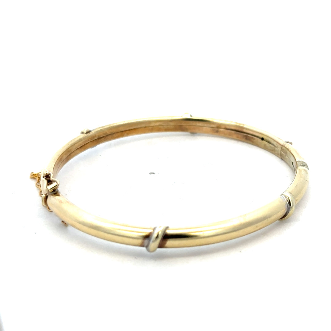 9ct yellow gold bangle weighing 11.1g, featuring a sleek and polished design, from Reeves and Sons.