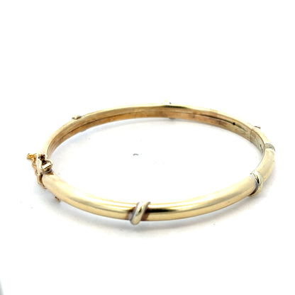 9ct yellow gold bangle weighing 11.1g, featuring a sleek and polished design, from Reeves and Sons.