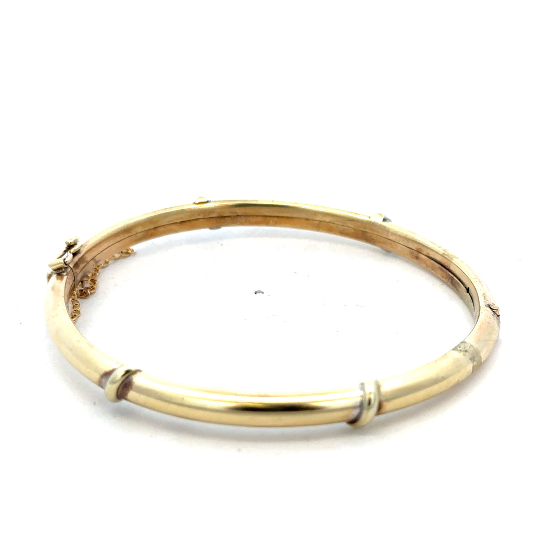 9ct yellow gold bangle weighing 11.1g, Reeves and Sons jewelry, polished smooth finish, circular design shown in the image.
