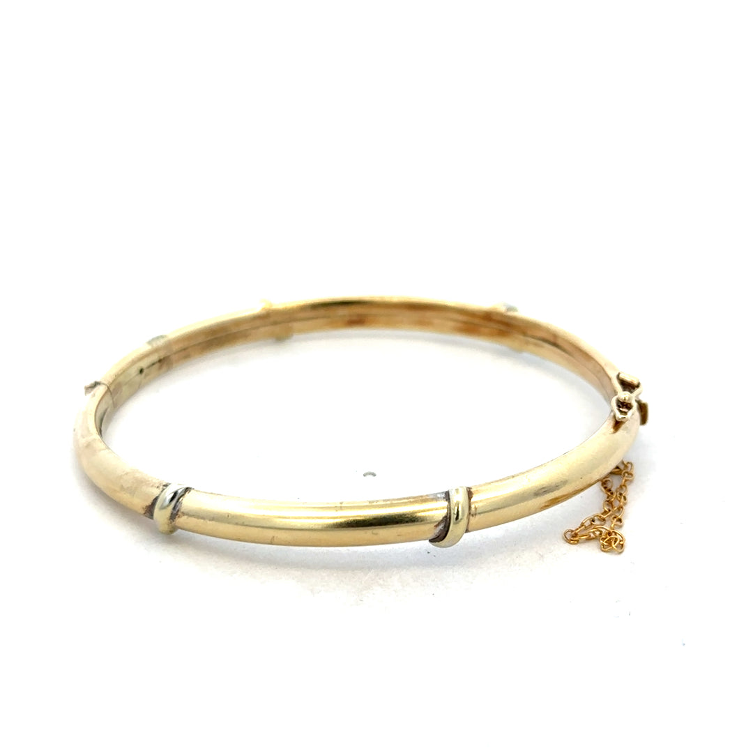 9ct yellow gold bangle weighing 11.1g with smooth, polished surface, designed by Reeves and Sons.