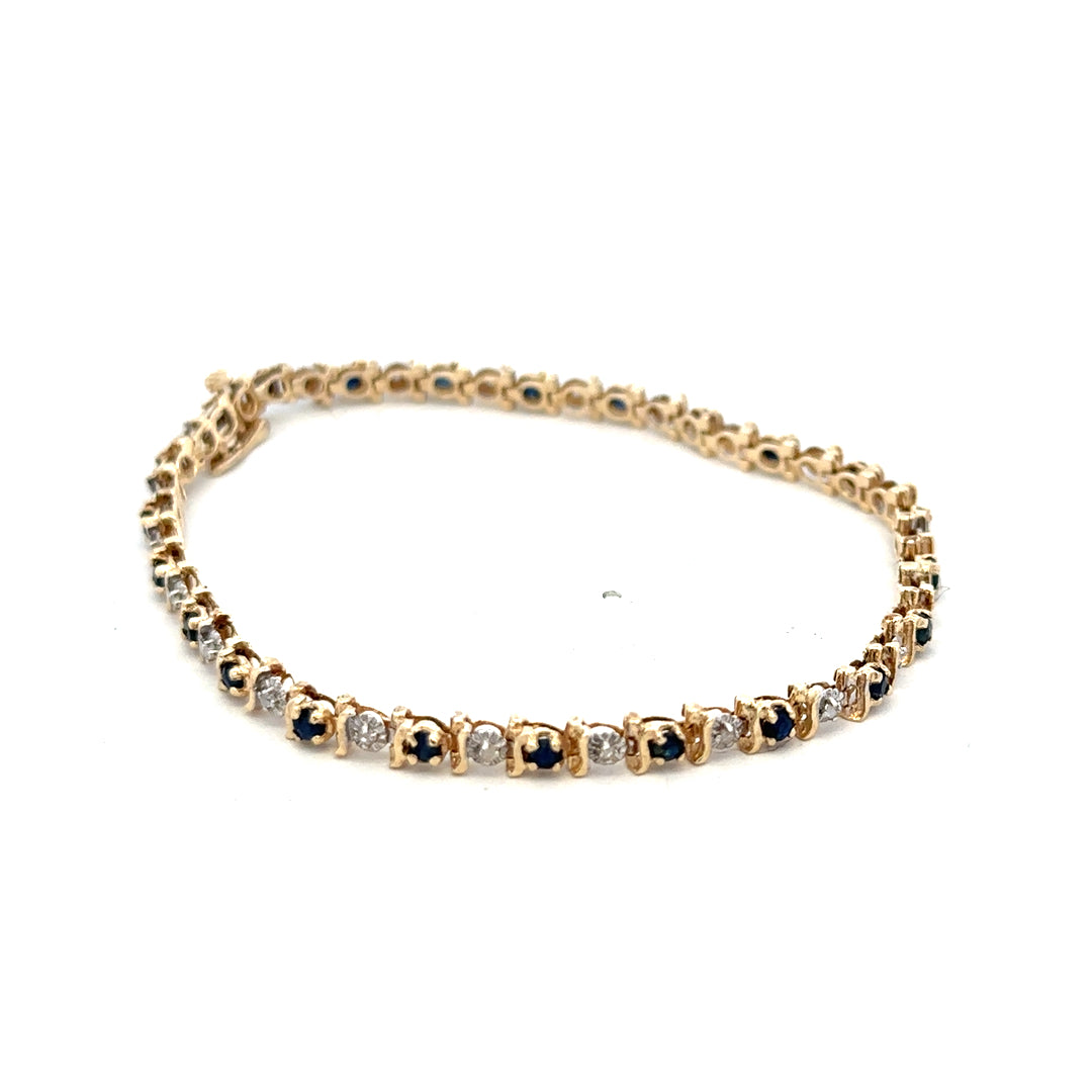 9ct yellow gold sapphire and diamond bracelet featuring sparkling stones, designed by Reeves and Sons, shown on a neutral background.