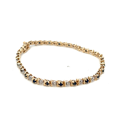 9ct yellow gold sapphire and diamond bracelet featuring sparkling stones, designed by Reeves and Sons, shown on a neutral background.