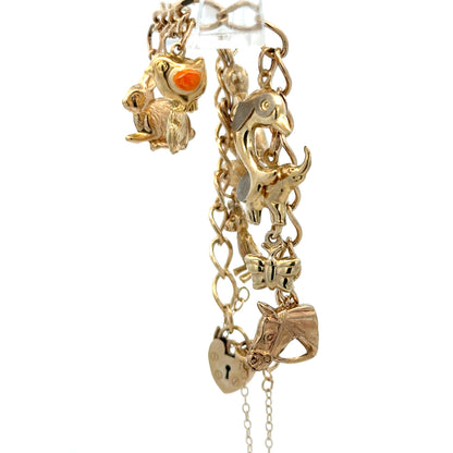 9ct yellow gold charm bracelet weighing 13.4g with various charms, crafted by Reeves and Sons.