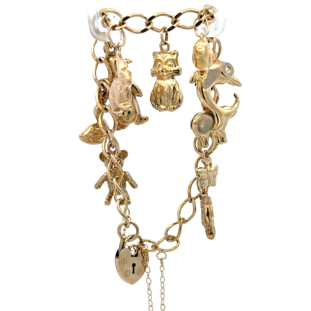 9ct yellow gold charm bracelet weighing 13.4g, featuring intricate charm details from Reeves and Sons.
