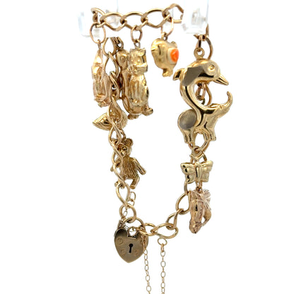 9ct yellow gold charm bracelet from Reeves and Sons with intricate charms, weighing 13.4g, showcased on a plain background.
