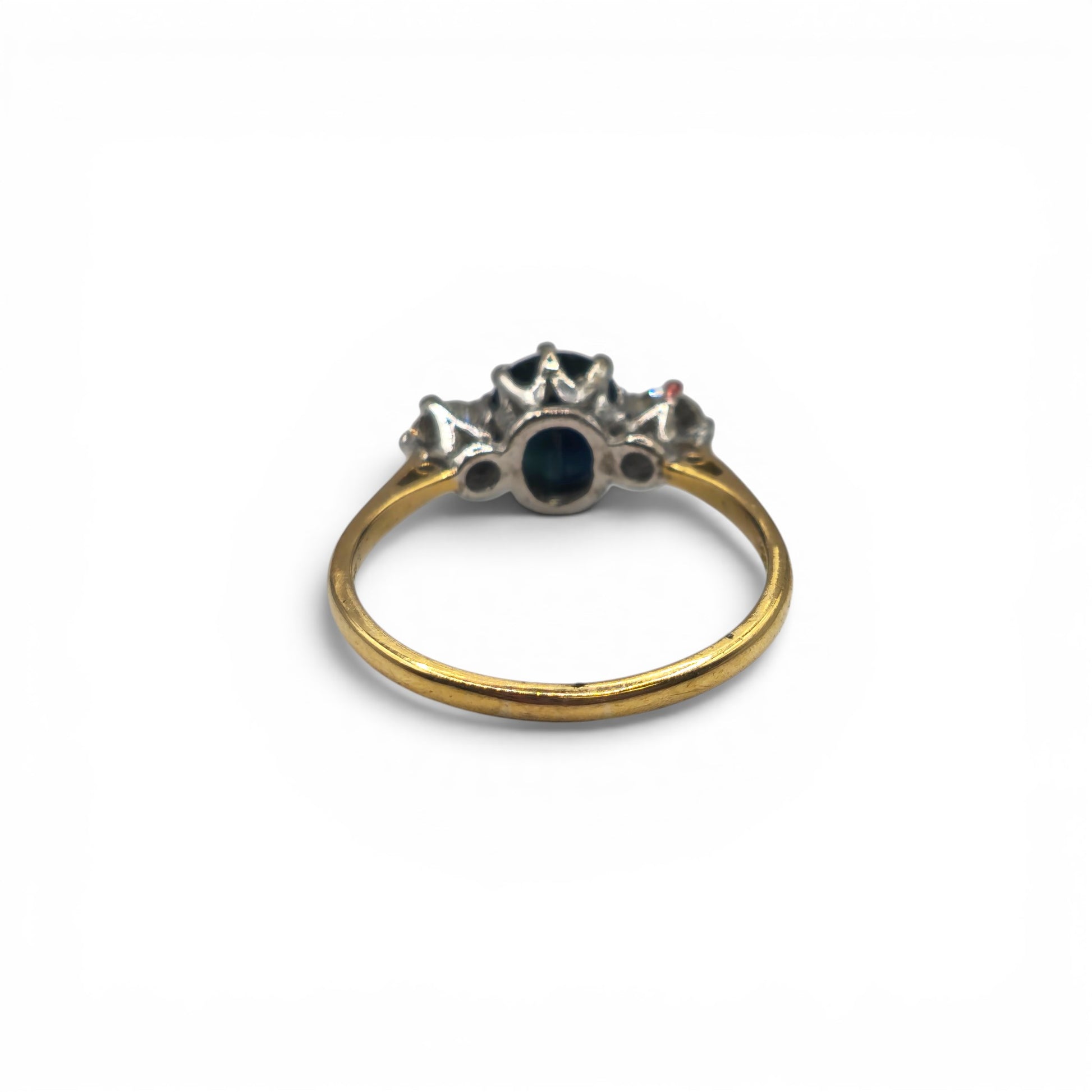 9ct yellow gold sapphire and diamond ring by Reeves and Sons, featuring a central sapphire gemstone and sparkling diamonds.