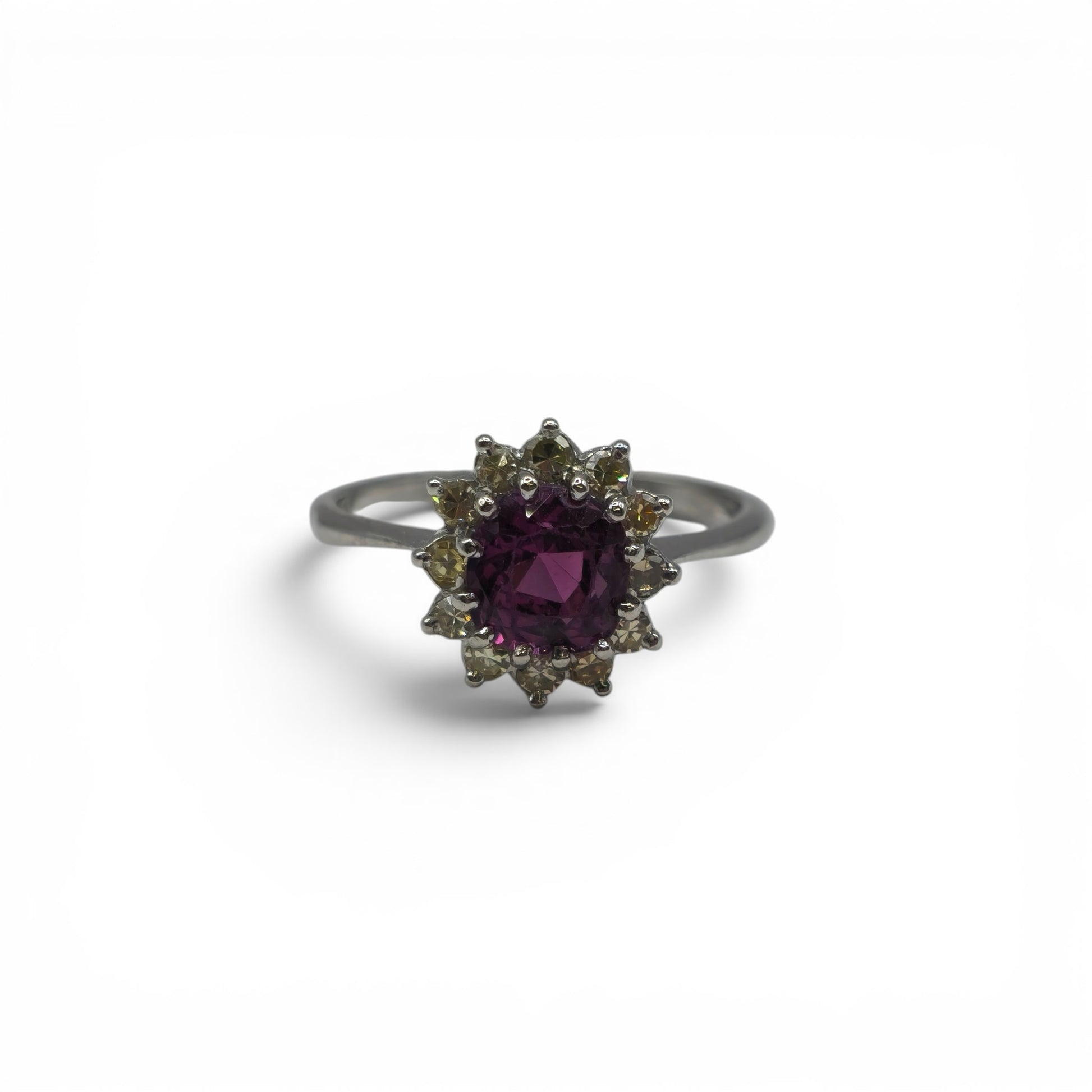 18ct white gold garnet and diamond ring by Reeves and Sons, featuring a central garnet gemstone surrounded by diamonds.