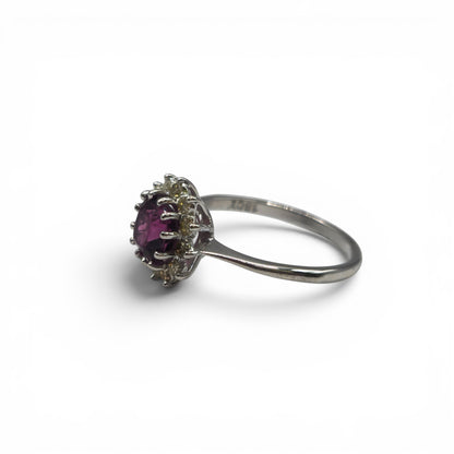 18ct white gold garnet and diamond ring by Reeves and Sons, featuring a central garnet gemstone and sparkling diamonds.