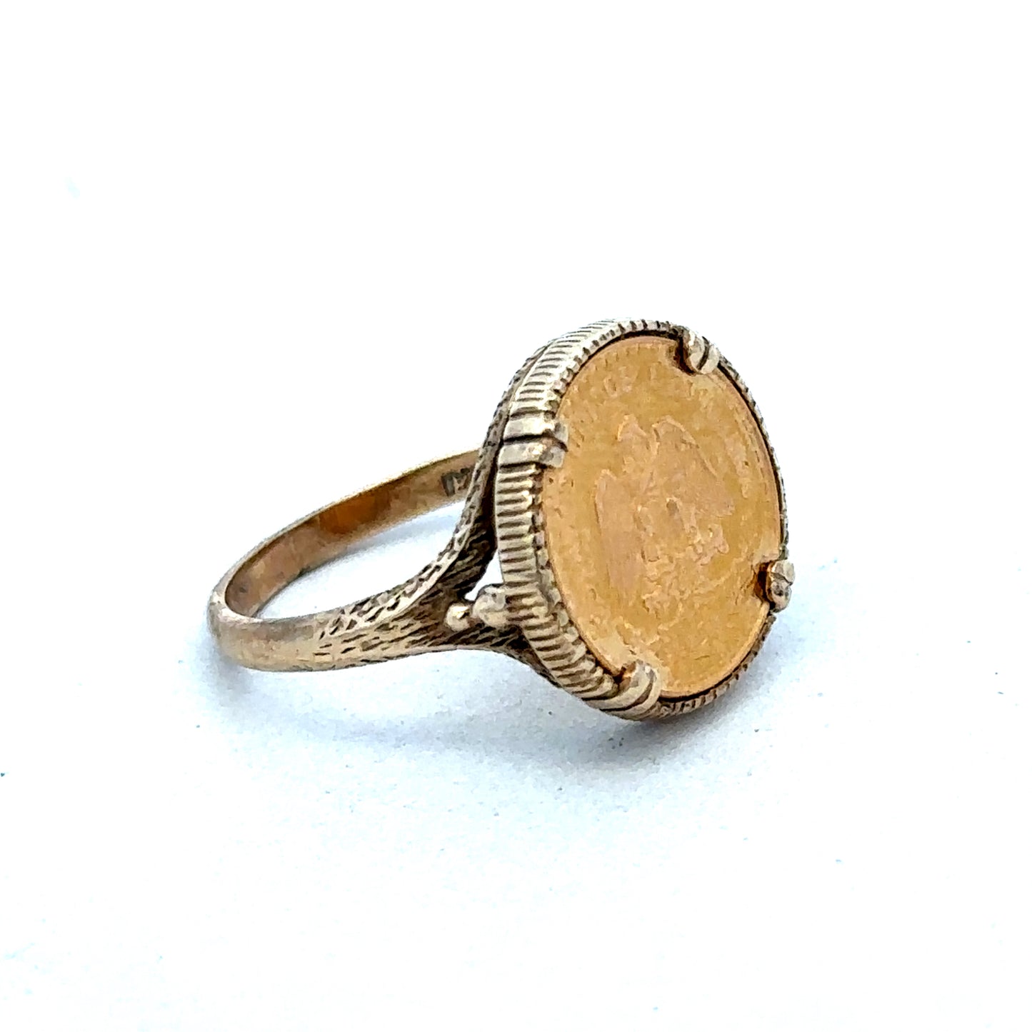 9ct gold Dos Pesos ring by Reeves and Sons, showcasing intricate design and craftsmanship on a polished gold band.